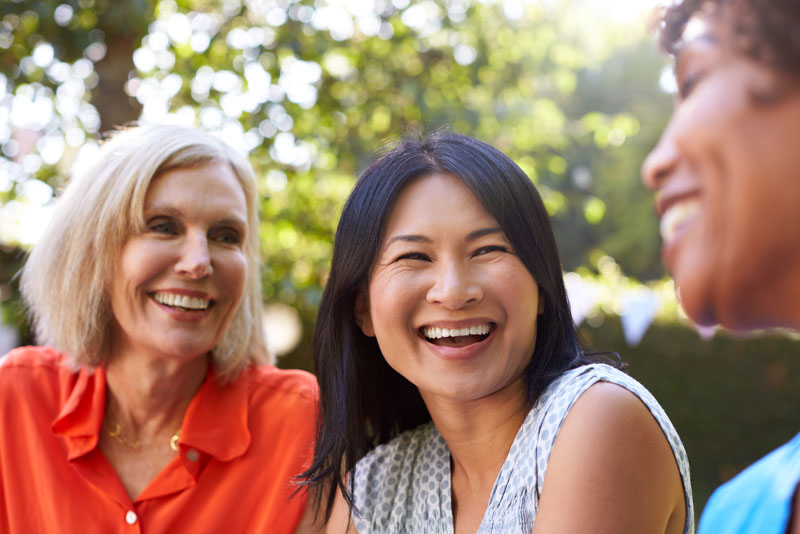 group of women with dental implants smiling and laughing