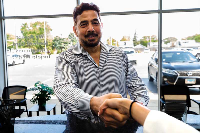 dental pateint shaking hands with dental receptionist